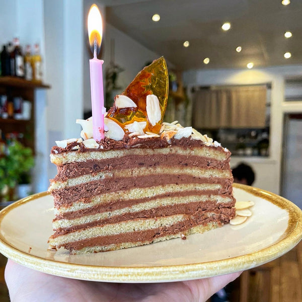 Our birthday cake with a lit candle in it: a Hungarian Dobos chocolate torte.