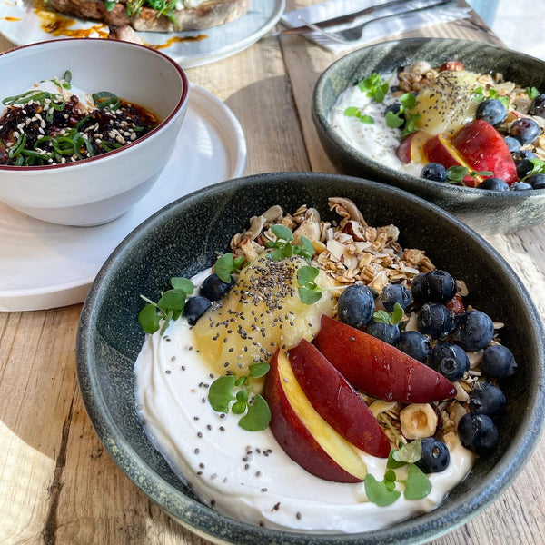 A brunch spread at the café featuring peach and blueberry granola and soy chilli eggs.