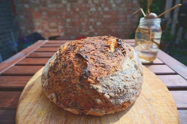 A loaf of Bread By Bike's hippy bread on a wooden board.