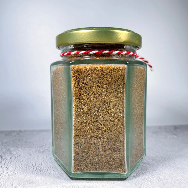 Side view of masala spice mix in a glass jar.